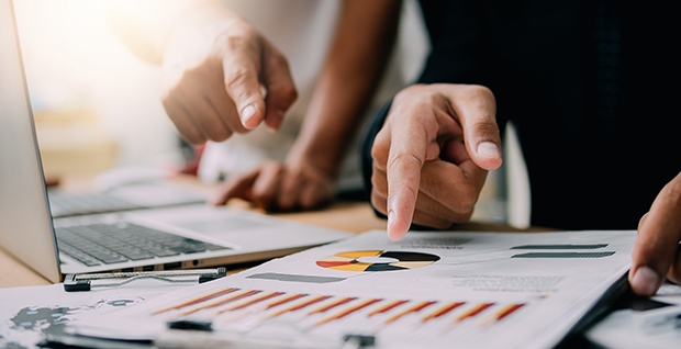 Profissionais de negócios que analisam tendências de negócios usando soluções de software de melhoria contínua.