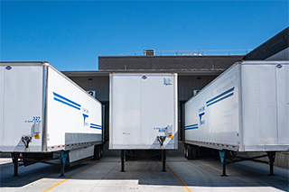 Reboques de caminhões semiarticulados estacionados em um armazém para carga e descarga.