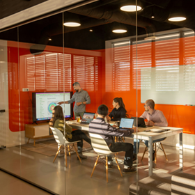 Colegas de trabalho se reunindo em uma sala de conferência para revisar um gráfico.